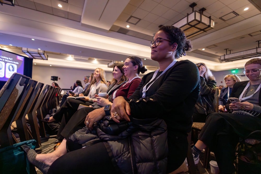 Audience members attending a women’s health innovation conference session focused on healthcare technology, care models, and women’s health strategy