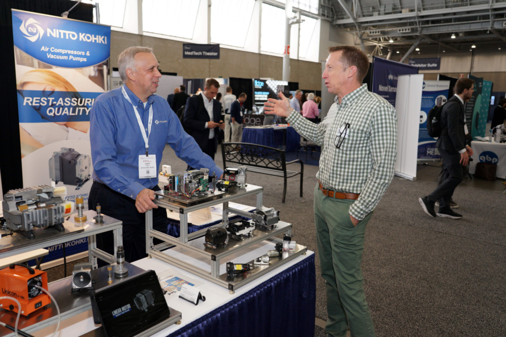 A conference attendee speaking with an exhibitor at the MEDevice Boston trade show